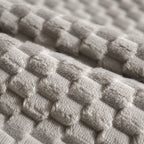 Close-up of Mincy Pets dog bed fabric featuring a soft, beige, textured plush flannel material with a grid pattern.