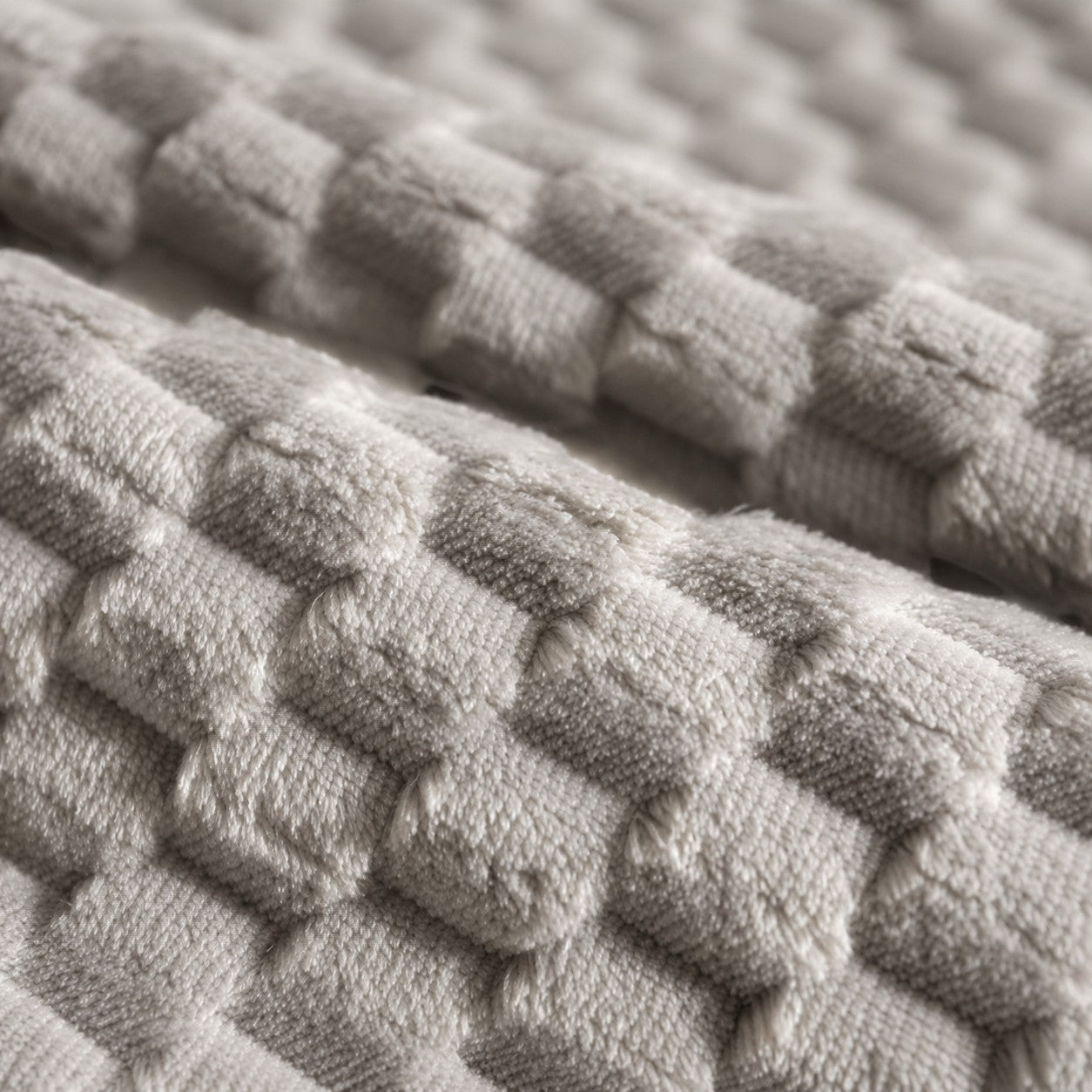 Close-up of Mincy Pets dog bed fabric featuring a soft, beige, textured plush flannel material with a grid pattern.