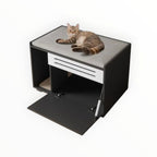 Mincy Pets cat litter box enclosure with a grey padded top, black cabinet, and white vent door, featuring a resting cat.
