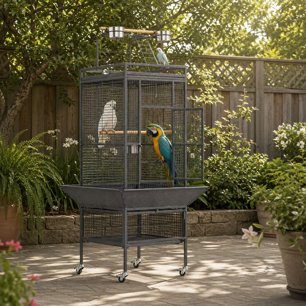 Mincy Pets large metal bird cage with play top, wood perches, and rolling wheels in a garden setting.